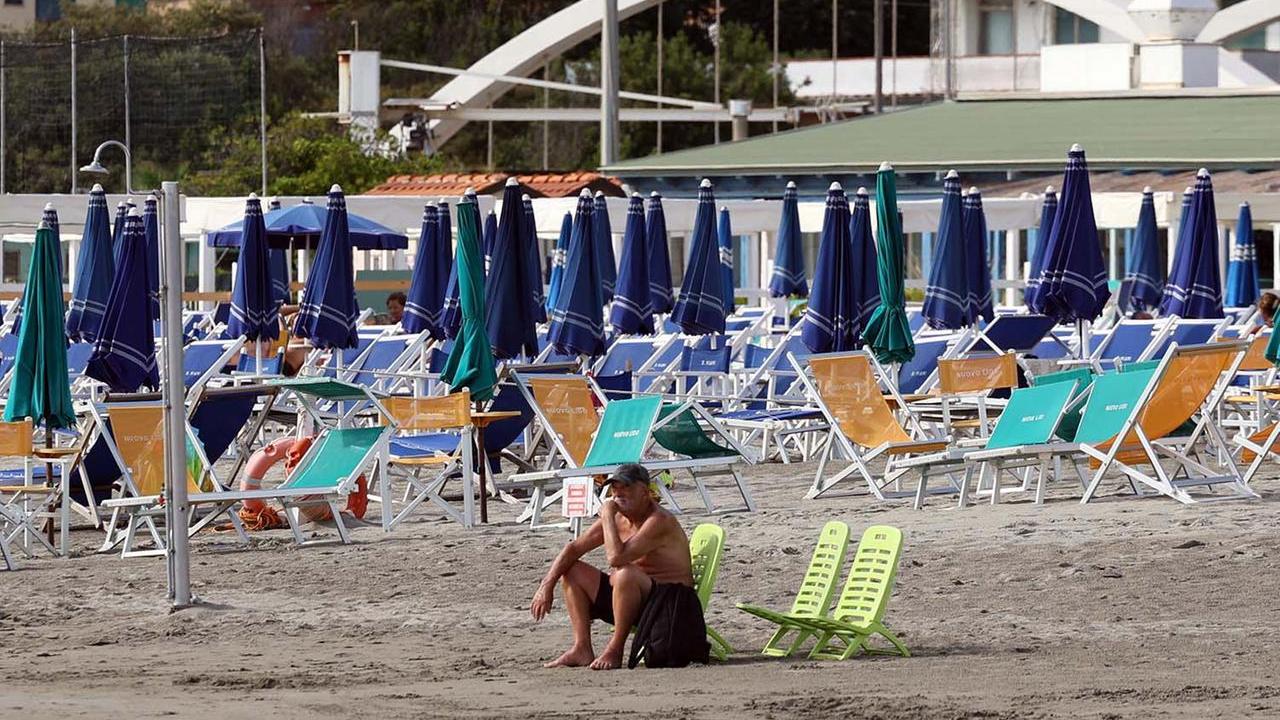Ombrelloni chiusi su una spiaggia del litorale massese