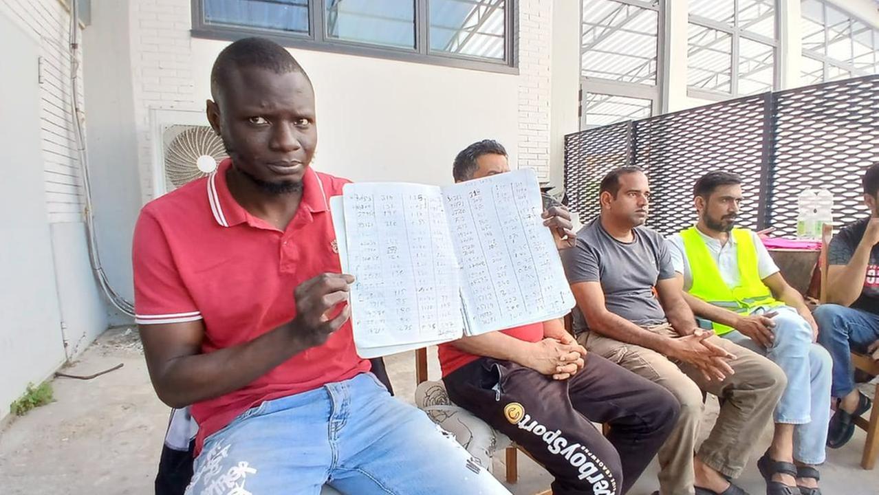 Talla Diagne mostra il registro del lavoro a cottimo