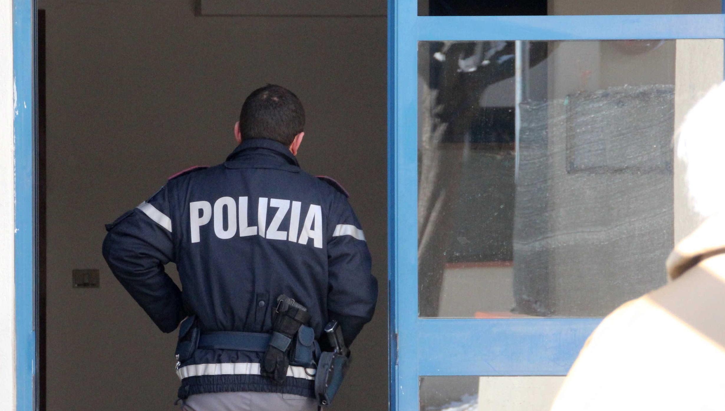 Un poliziotto mentre entra in uno stabile di via Guadalajara (foto d'archivio)