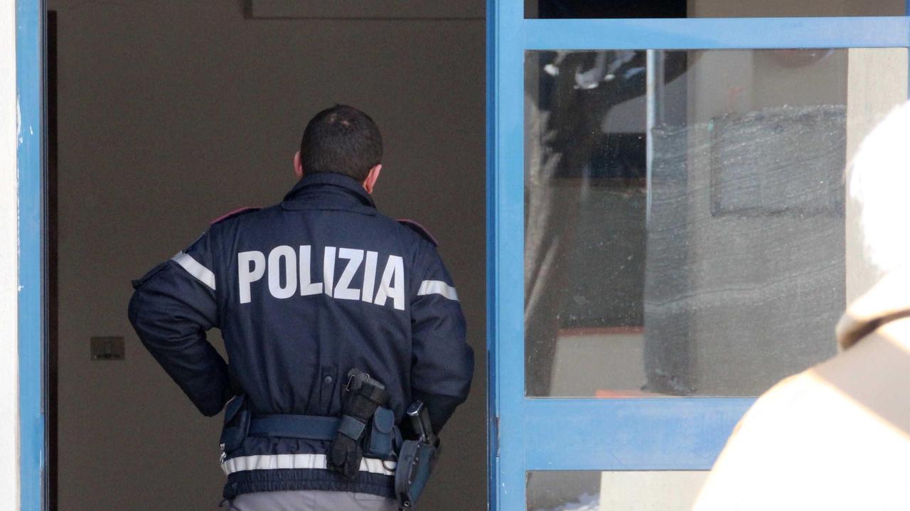 Un poliziotto mentre entra in uno stabile di via Guadalajara (foto d'archivio)