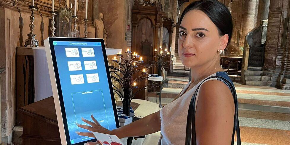 
	Una turista mentre effettua una donazione in Duomo

