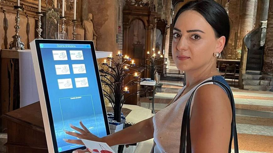 Una turista mentre effettua una donazione in Duomo