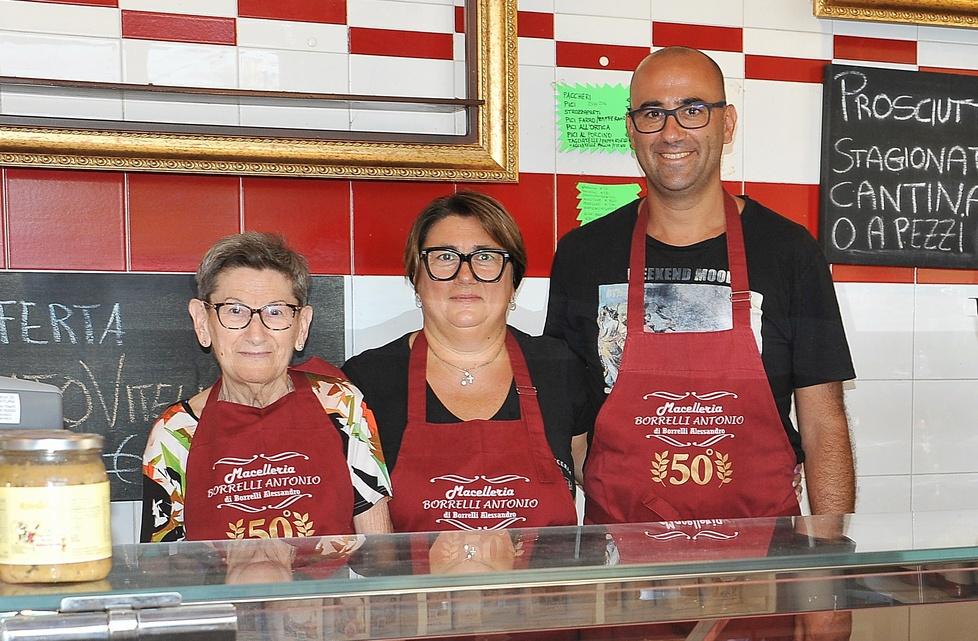 
	Alessandro e Silvia Borrelli con la madre Luciana Costi nella macelleria norcineria Borrelli

