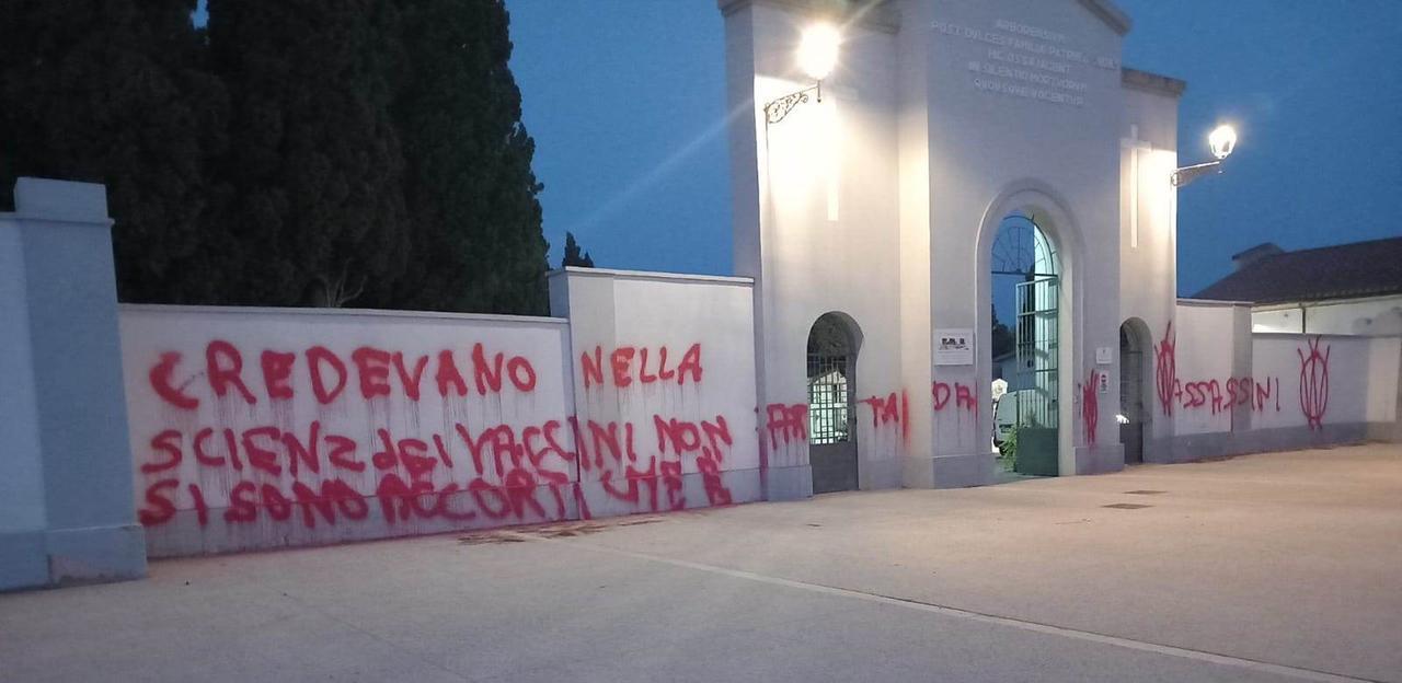 Vandali oltraggiano il cimitero con scritte no vax sui muri