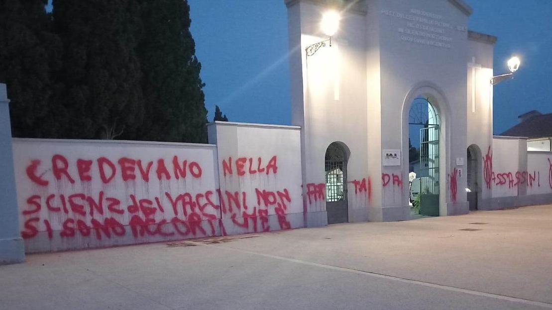 Vandali oltraggiano il cimitero con scritte no vax sui muri