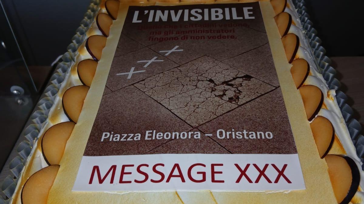 La mattonella rotta della piazza diventa decorazione per la torta di protesta al sindaco. Lui la rimanda indietro