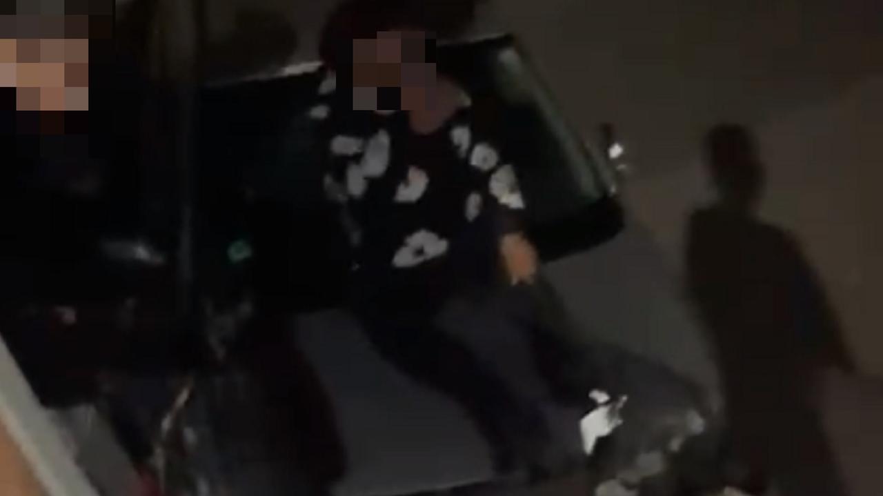 Uno dei ragazzi sdraiato dolorante sull'auto colpita