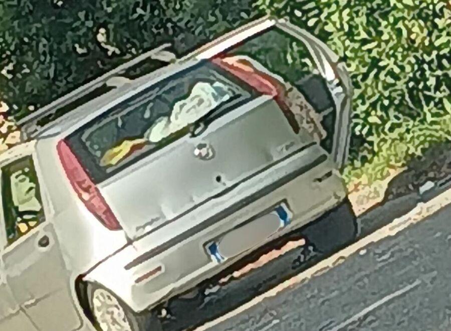 
	La donna mentre scarica i sacchi dalla sua auto per lasciarli nel parcheggio

