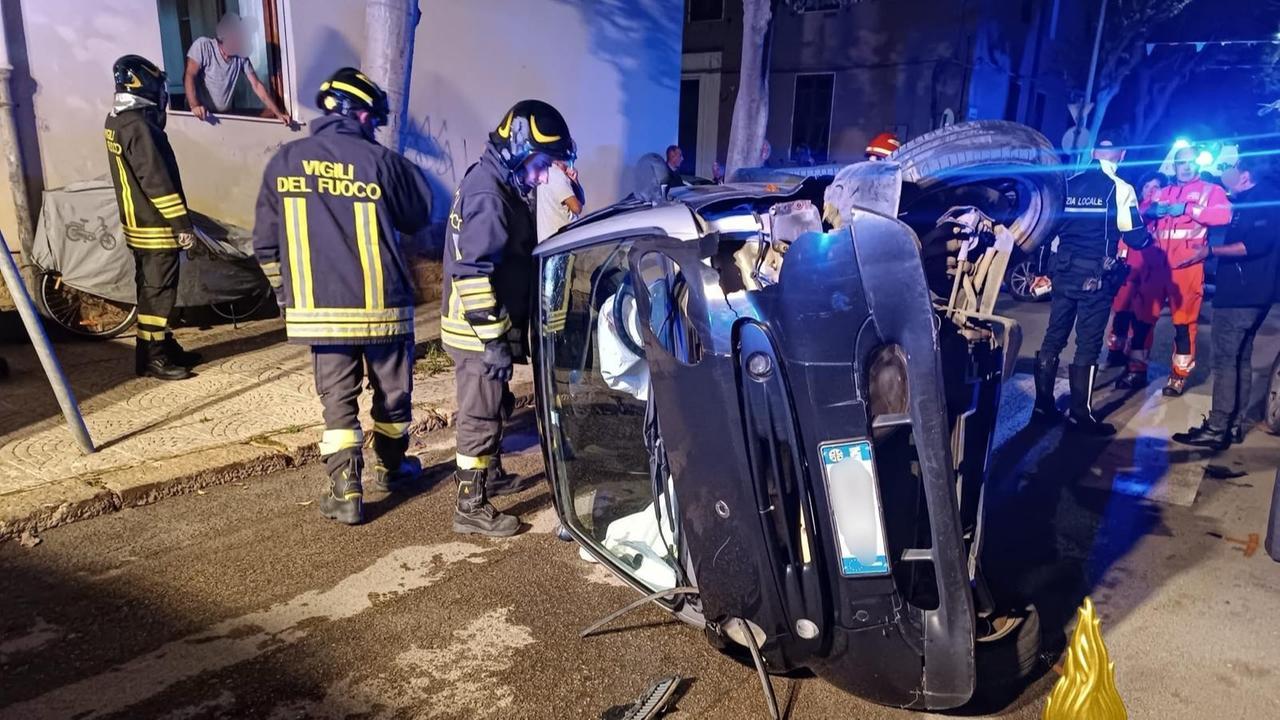 Auto si schianta sulle macchine in sosta, poi si ribalta