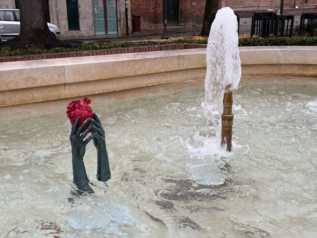 Braccia con cuore rosso. Chi è Hxoro, l’artista dell’installazione nella fontana a Ferrara