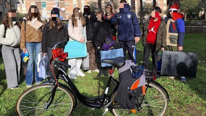 Foto di gruppo a scuola con gli studenti e la bicicletta ricomprata allo studente