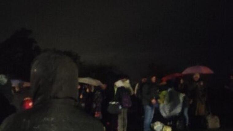 Alcuni passeggeri sotto la pioggia fuori dalla stazione di Santa Severa