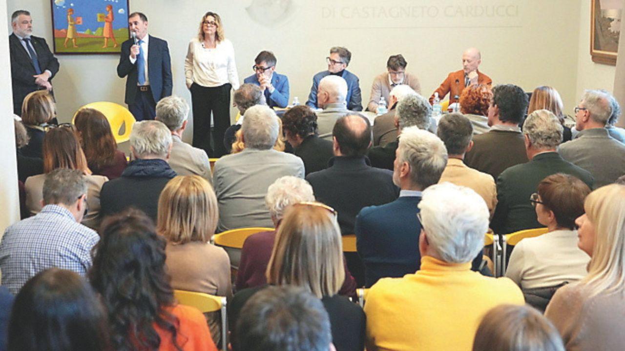 Il tavolo del confronto e il pubblico nella sede di Castagneto Banca a Livorno (foto Stick)