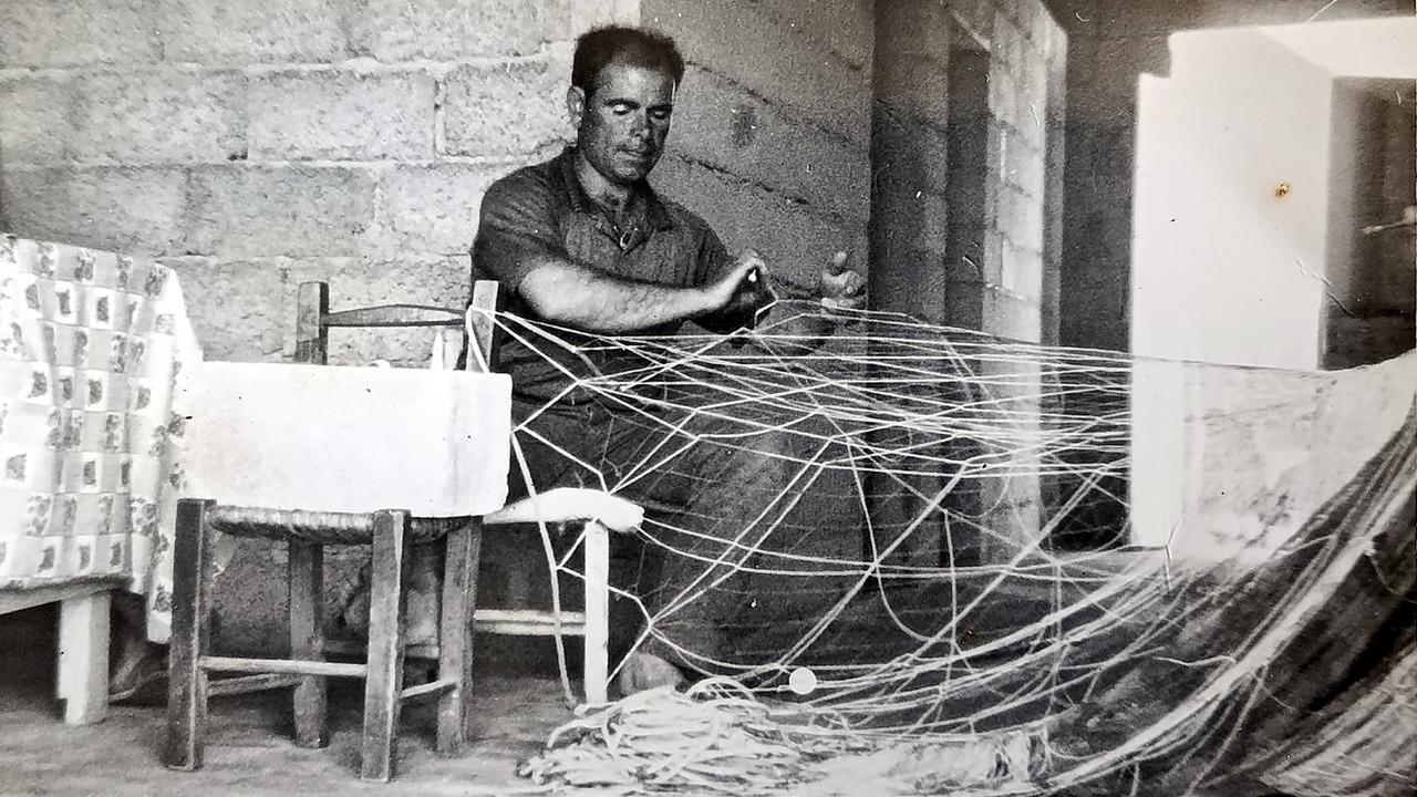 Francesco Manca pescatore di Cabras in gioventù intento a riparare una rete