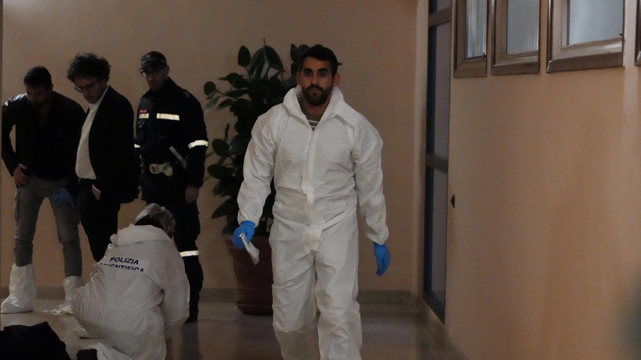 I poliziotti con il pm Niccolò Volpe nell'androne del palazzo teatro dell'omicidio (foto Stick)