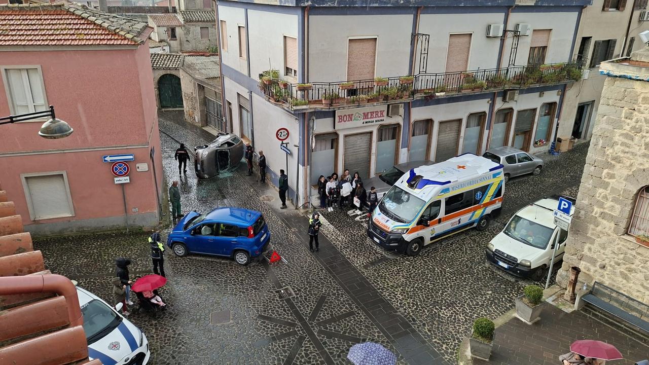 Scontro tra auto in paese, mamma e due bimbi restano intrappolati: un residente spacca il parabrezza con il piccone per liberarli