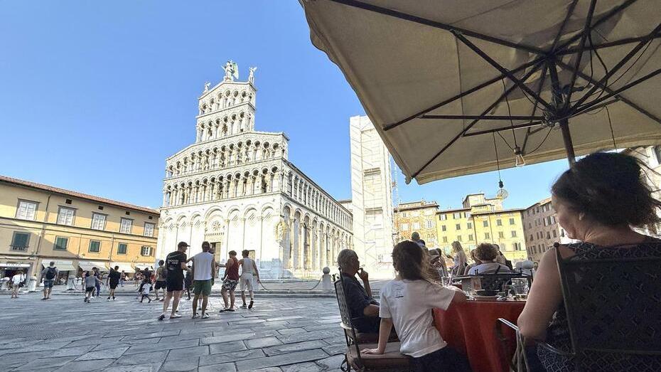 Turisti seduti a un caffè in piazza San Michele (foto archivio)