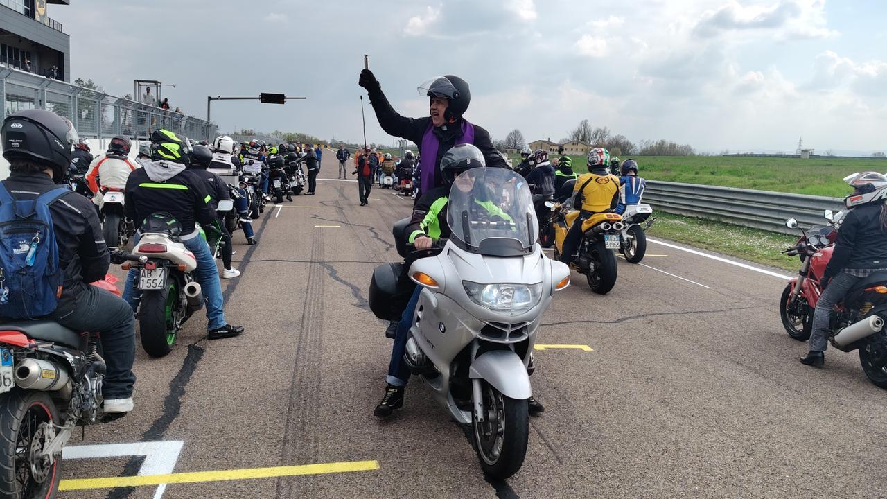Don Giulio in sella alla moto all’Autodromo di Modena benedice i piloti: fede e passione a tutta velocità