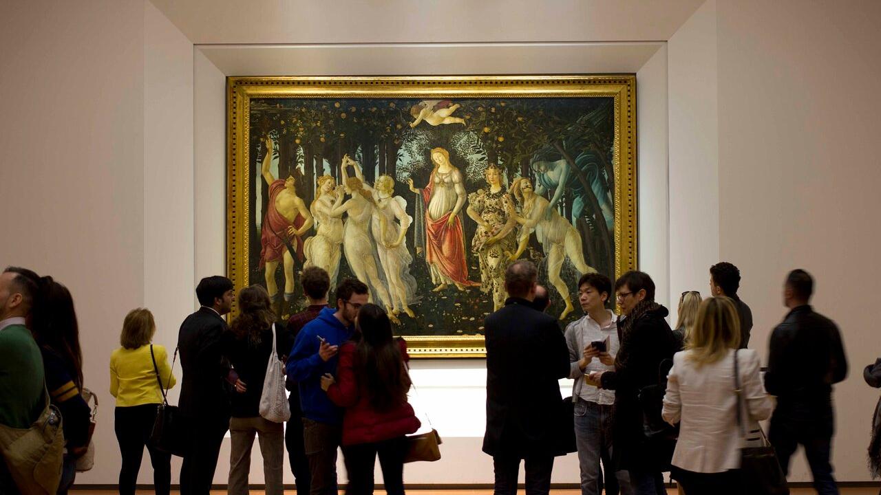 Turisti in visita agli Uffizi mentre osservano la Primavera del Botticelli