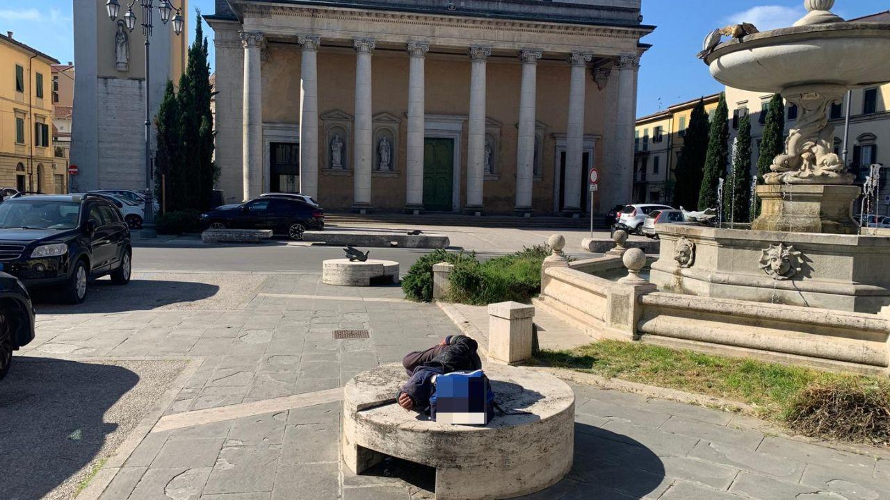 Il senzatetto picchiato mentre dorme su una seduta a fianco della fontana di fronte al Duomo di Pontedera