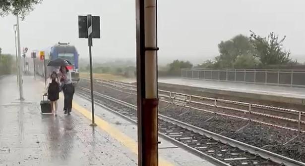 Il treno ha un guasto, i passeggeri devono aspettare l’autobus sotto il diluvio: VIDEO