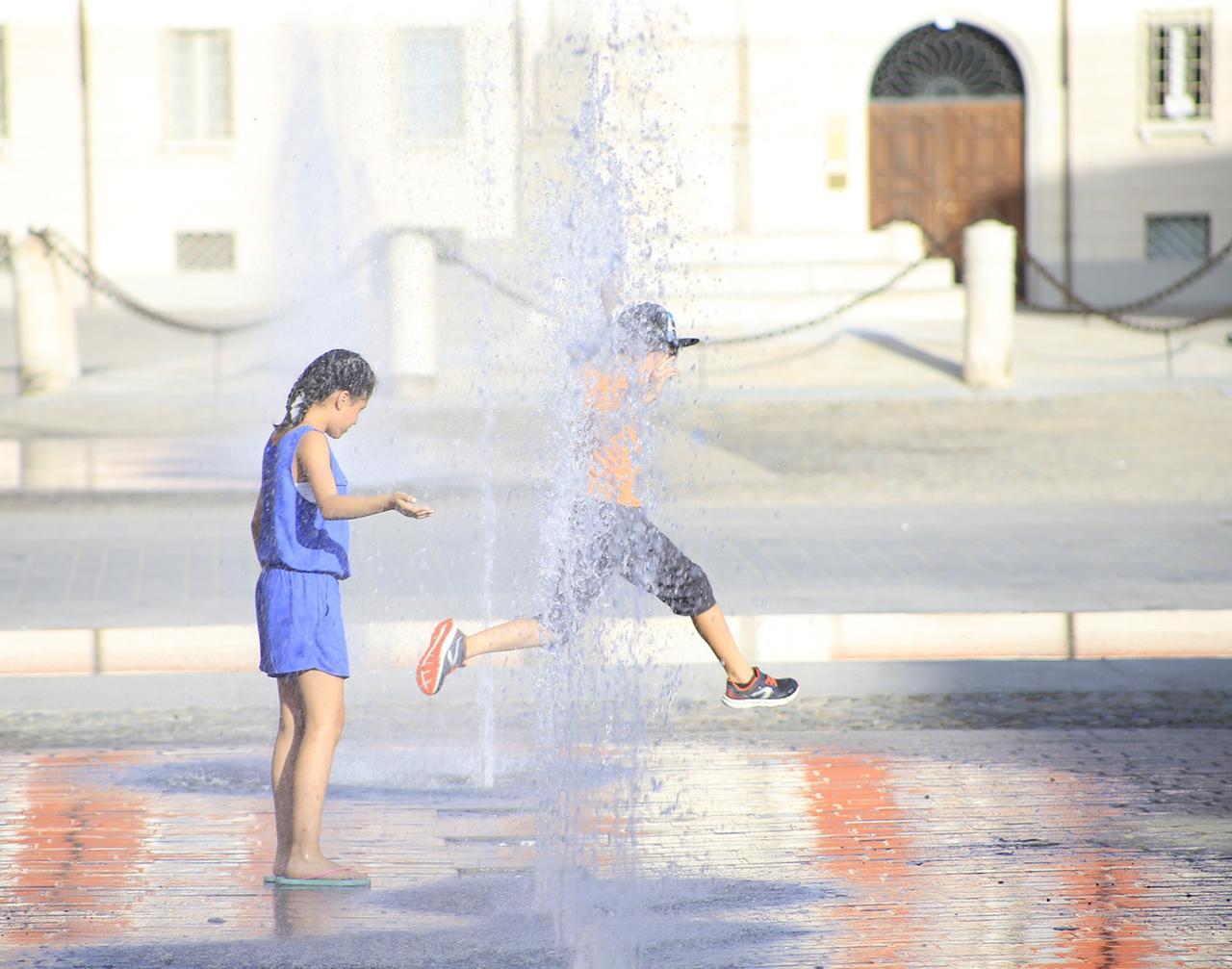 
	Due bambini si rinfrescano nella fontana di piazza Roma (Foto: Luigi Esposito)

