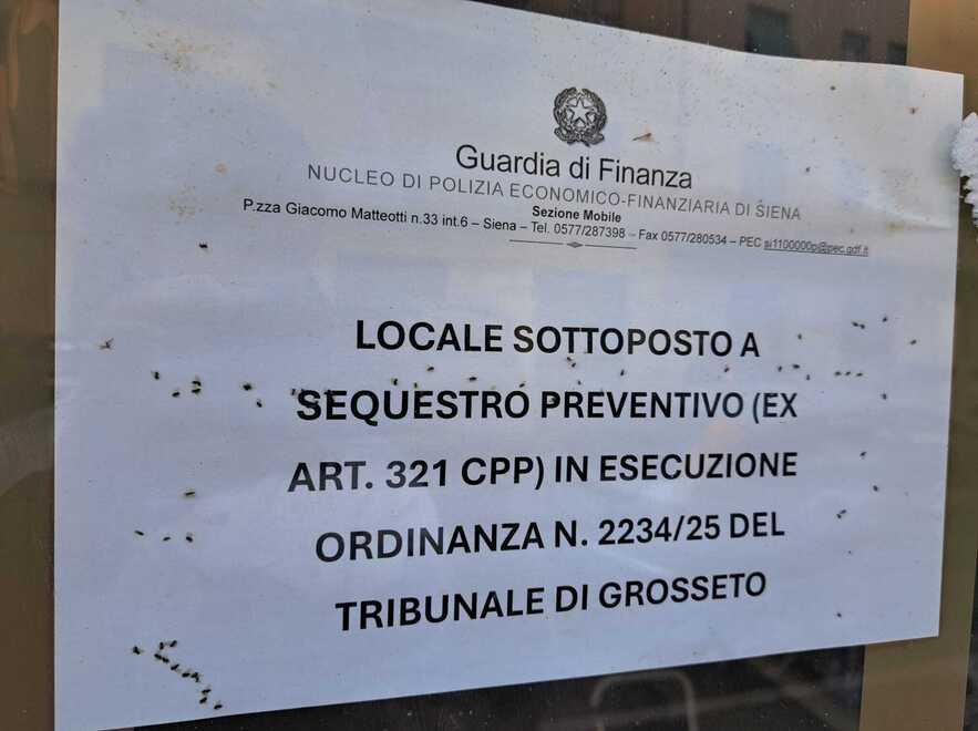 
	L&rsquo;ordinanza di sequestro preventivo sul vetro del mini-market.&nbsp;Come si pu&ograve; vedere decine di moscerini sono ammassati tra la vetrata e il cartello

