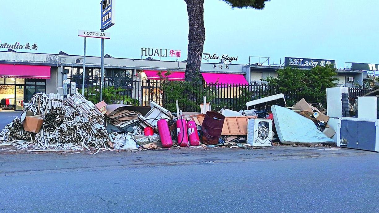 Rifiuti sul marciapiede in una strada del Macrolotto