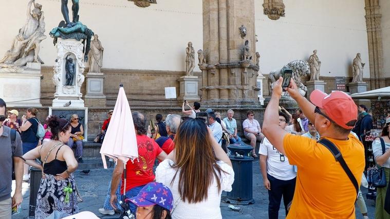 Turisti in piazza della Signoria ammirano la Loggia dei Lanzi