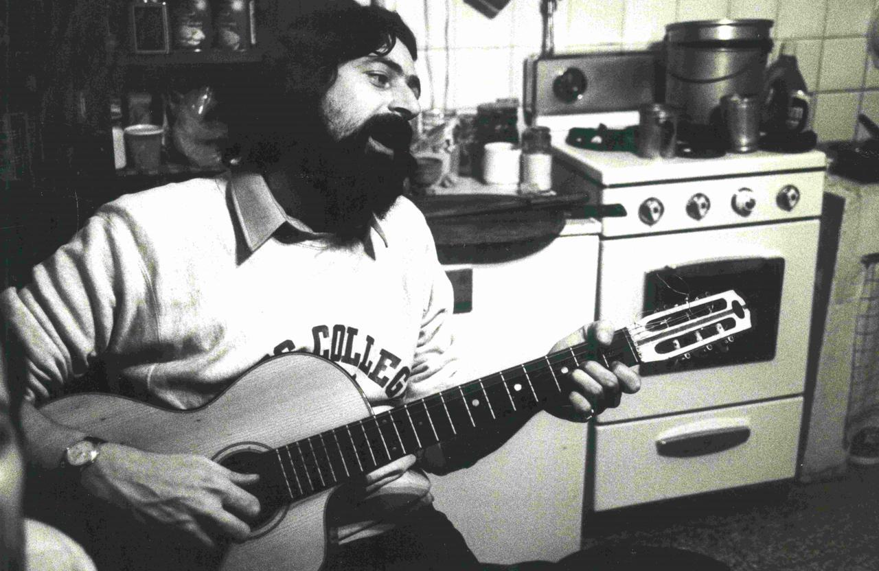 
	Un giovane Guccini alla chitarra in cucina

