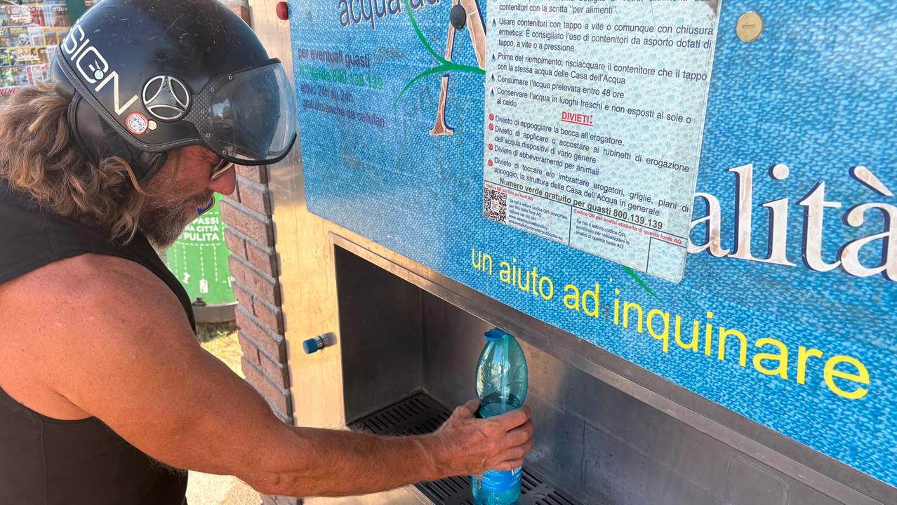 Un livornese mentre si disseta a un fontanello gratuito di Asa (foto Stick)