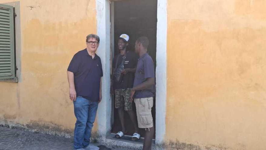 Don Biancalani insieme a due giovani che sta ospitando nella canonica della chiesa di San Niccolò a Ramini