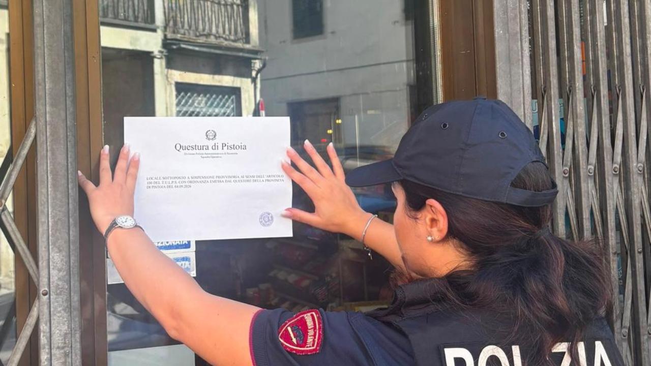 Una agente colloca la notifica del provvedimento 