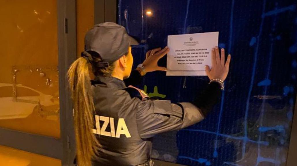 Una poliziotta davanti al locale chiuso per 30 giorni