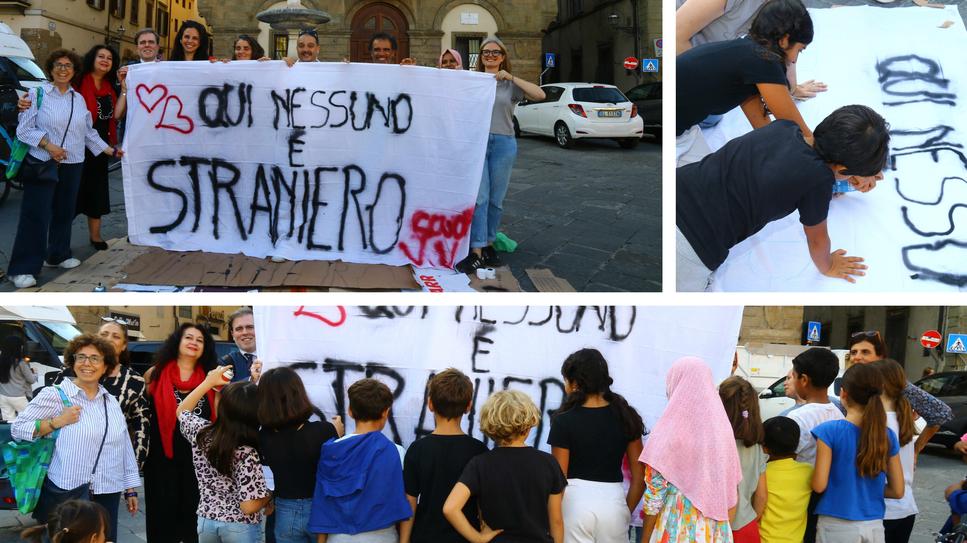 I bambini della Vittorio Veneto e della Pestalozzi in piazza Santa Croce mentre ridisegnano lo striscione «Qui nessuno è straniero»