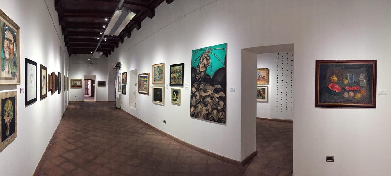 ORISTANO Un allestimento alla pinacoteca Carlo Contini; in alto una foto della  mostra Novecento ospitata qualche anno fa