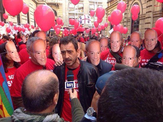 I dipendenti Meridiana indossano la maschera che ritrae l'Aga Kahn