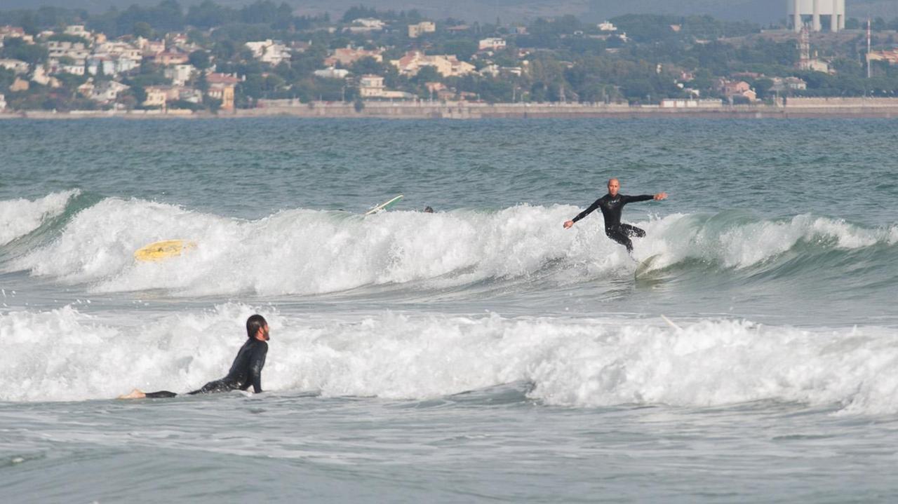 E' bastata una leggera schiarita perché lo specchio di mare del Poetto si riempisse di surfisti (foto Rosas)