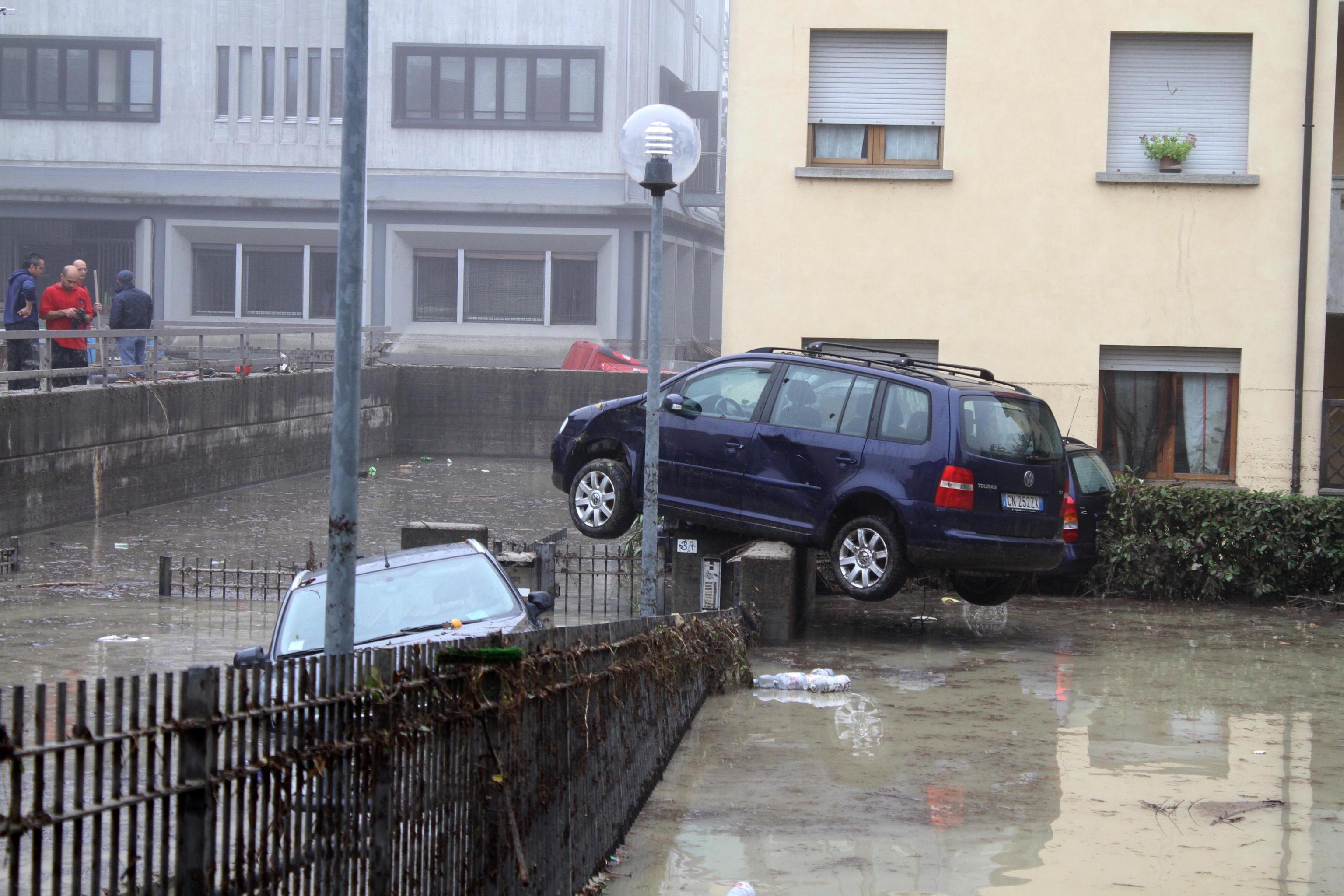 Un'auto in bilico sul muretto di una palazzina
