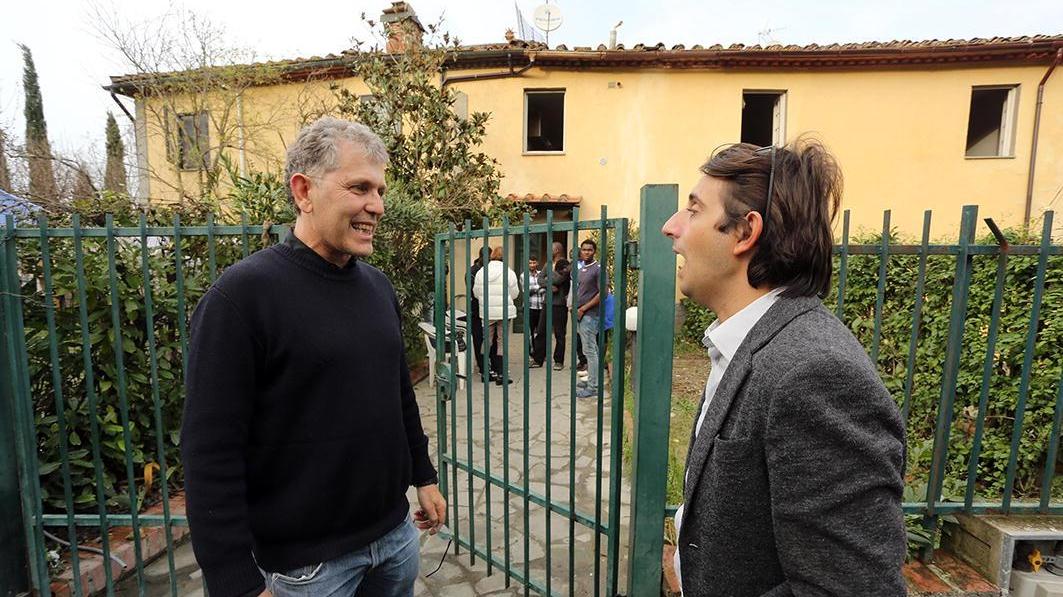 Il consigliere Giovanni Donzelli (a destra) e David Santetti della Misericordia (a sinistra) sullo sfondo gli immigrati (foto Sestini)