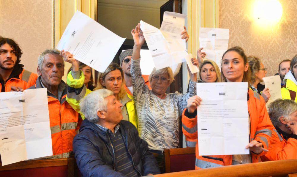 Gli spazzini Cooplat in consiglio comunale mostrano le lettere di licenziamento (Silvestri Pentafoto)