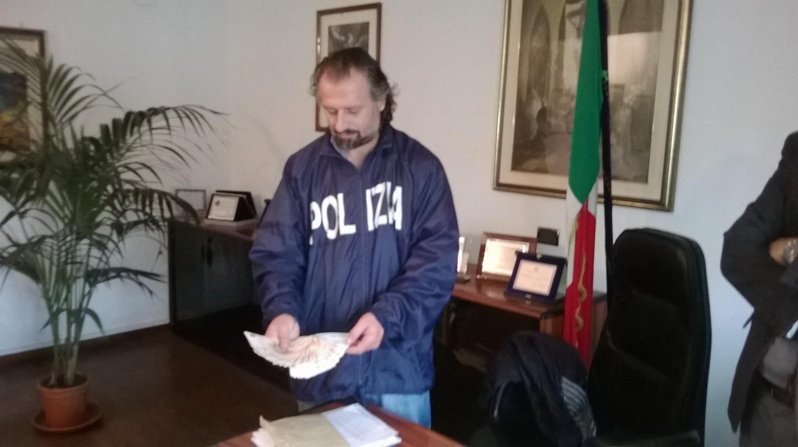 Un investigatore della Mobile mostra il denaro recuperato prima che venga riconsegnato all'anziana pensionata