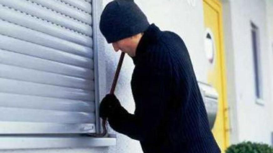 Un ladro forza la finestra di una casa (foto d'archivio)