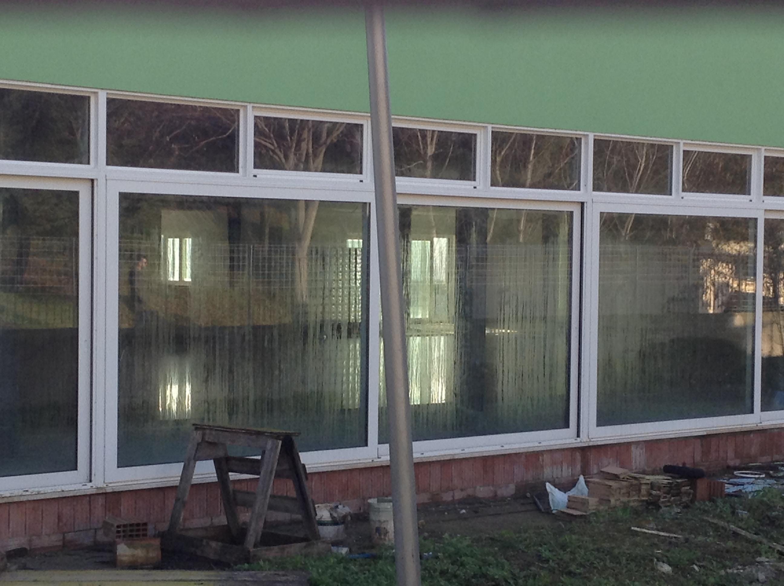 Aldilà dei vetri la vasca piena d'acqua della nuova piscina