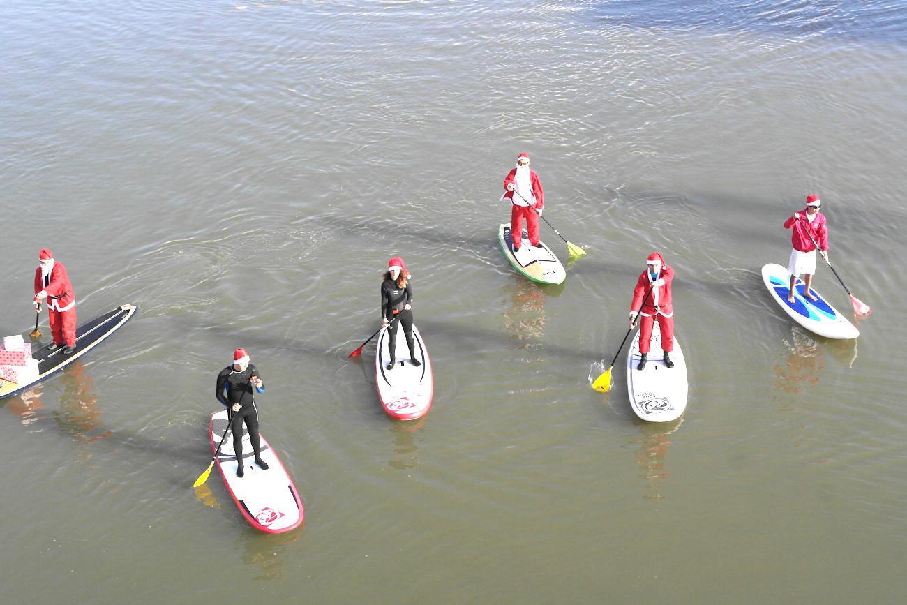 I Babbi Natale sui surf in Arno