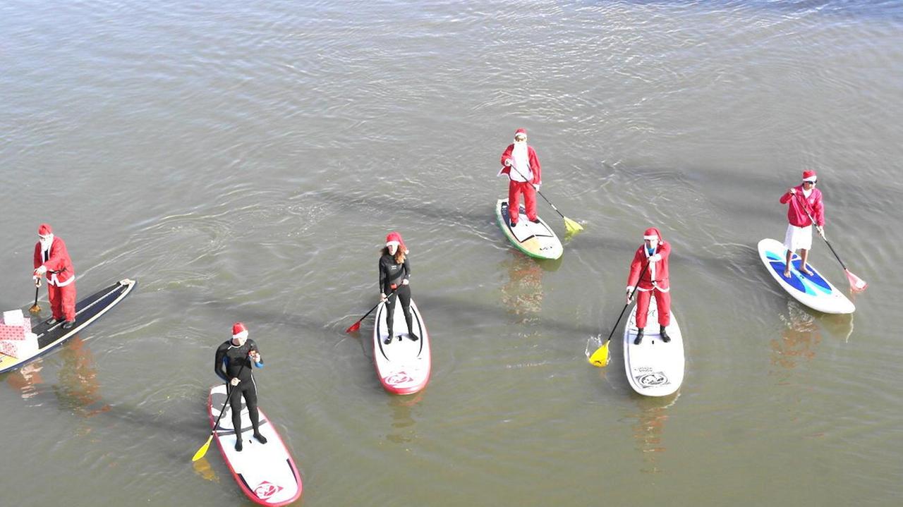 I Babbi Natale sui surf in Arno