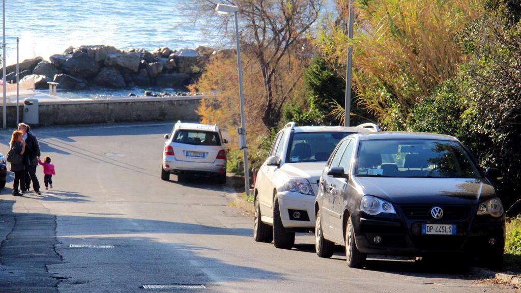 Le auto lasciate in sosta lungo la via col senso unico alternato