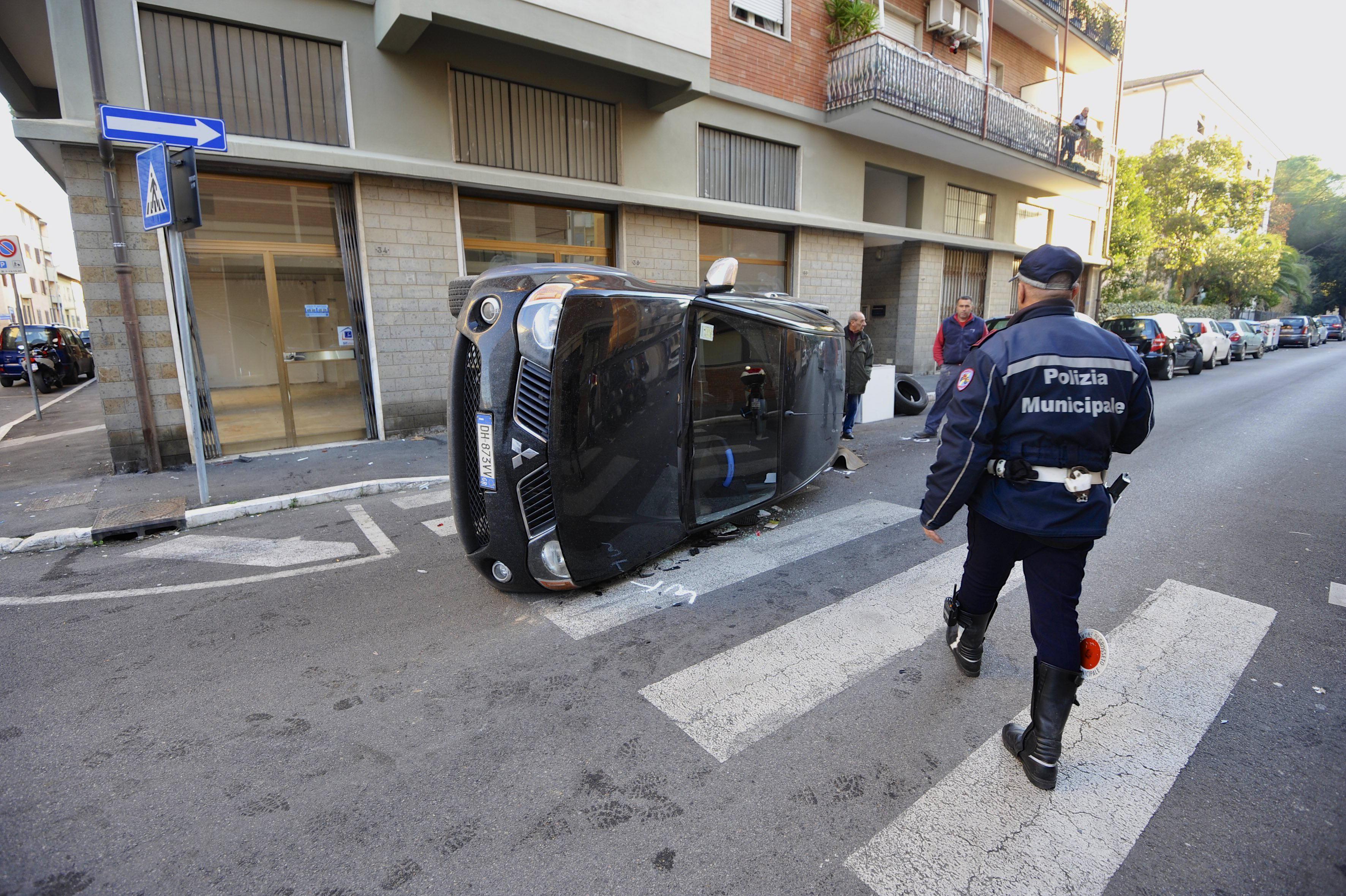 L'auto rovesciata in centro (foto agenzia Bf)
