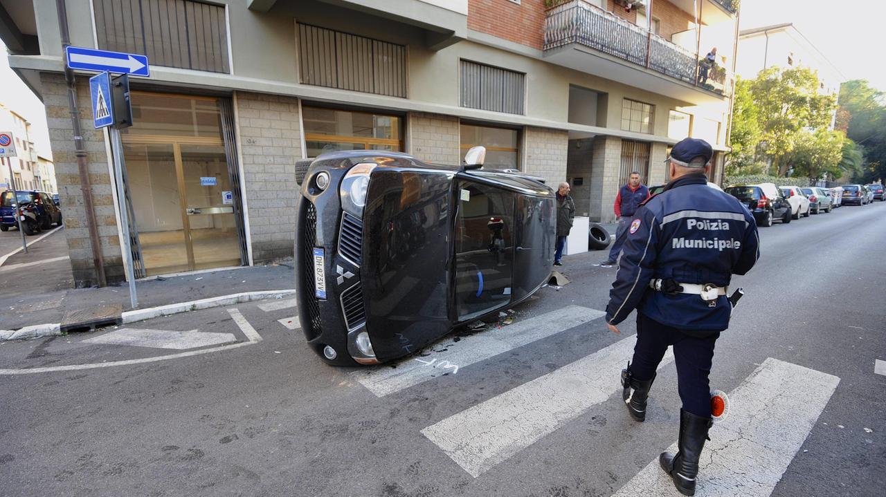 L'auto rovesciata in centro (foto agenzia Bf)