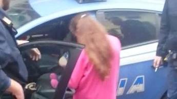 La bambina prende il peluche dalla volante della polizia